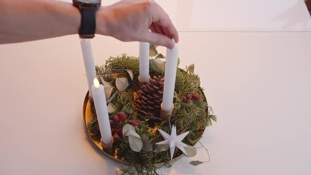Turning On Electric Candles on Christmas Advent Wreath