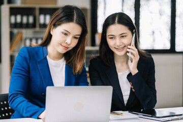 Business women or accountant working on laptop computer with business document, graph diagram and calculator on office table in office.