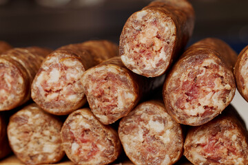 Homemade sausages cut into pieces placed on a wooden chopper.