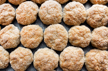 Homemade pastries on a baking sheet close-up. Dough cakes sprinkled with sugar