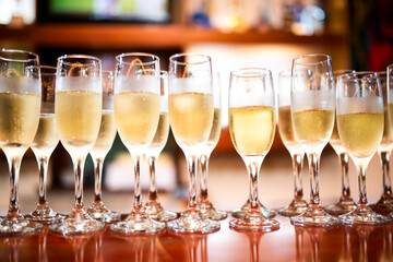 Glasses of sparkling champagne placed in a row on a table.