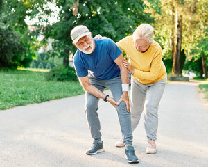 senior fitness man woman active sport exercise injury pain running jogging ache leg knee ankle wrist muscle accident support help teamwork together assistance outdoor training injured sprain hurt