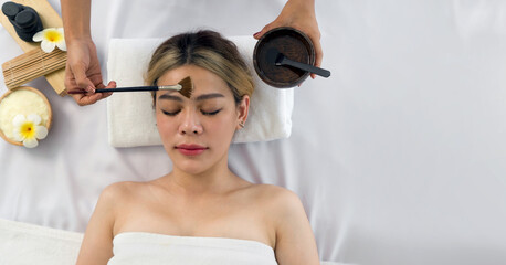 Young asian woman with nutrient facial, getting facial care by beautician at spa salon, Top View....