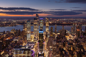 Aerial view of Midtown West Manhattan toward Hudson River with Hudson Yards skyscrapers at twilight. Chelsea and Hell's Kitchen neighborhood of New York City - 705618013