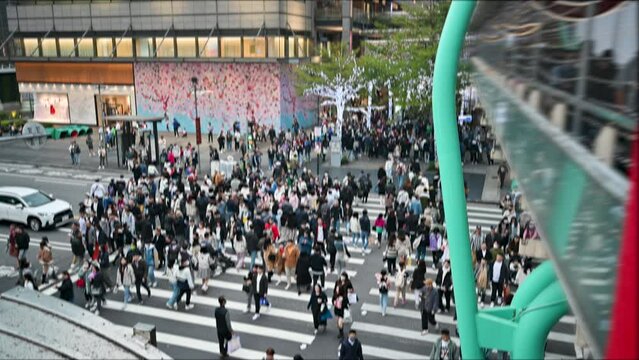 Blurred scene of pedestrians crossing the sidewalk at a busy intersection. People preparing for New Year's Eve and shopping in Xinyi District, Taipei.