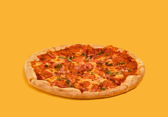Yummy green hot pepper pizza on a yellow background. Delicious restaurant lunch.