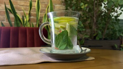 A white cup of green natural tea with ginger, lemon and honey. High quality 4k footage