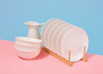 Set of white kitchen ceramic tableware. Dishes assortment. Wooden dish rack.