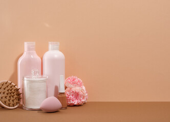 Natural spa treatment on a beige background. Face wash and cleansing gels, cotton pads, cosmetic sponge, nail polish and massage brush. Copy space for text.