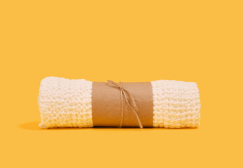 A clean, soft shower towel on a yellow background. Beauty shower concept.