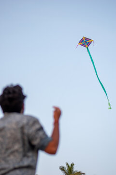 A picture of a guy flying a kite