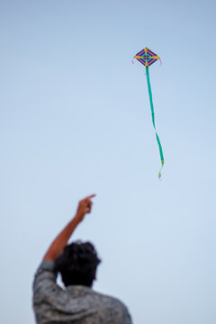 A picture of a guy flying a kite