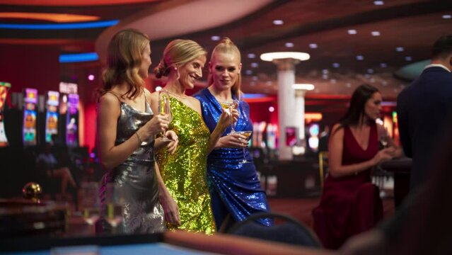 Successful Women in Chic Evening Dresses, Confidently Walking into a Luxury Casino. Celebrating a High-Achieving Girls Night Out with Elegant Cocktails, Smart Bets, Winnings and Stylish High Life