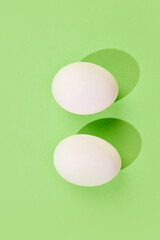 White eggs on green background. Top view. Template for greeting card. Concept of Easter holiday, celebration, traditions, happiness. Postcard. Empty space for ad