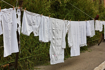 Old underwear and sheets hanging to dry. Laundry hung out, clothesline with ancient linen - 705634464