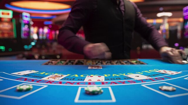 Online Casino: Professional Croupier Deals Cards on Blackjack Table: Anonymous Male Game Dealer Masterfully Revealing possible Jackpot Winning Hand, Excitement in High Stakes Game. Closeup Static shot