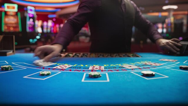 Casino Card Game Table: Professional Dealer Running a Blackjack Game. Anonymous Male Croupier Dealing Playing Cards for Placed Bets. Betting on Payout, Strategy and Luck. Zoom in Cinematic Shot