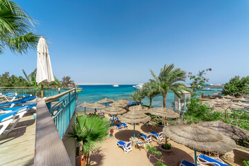 view from the top of the beach with umbrellas of reeds boats