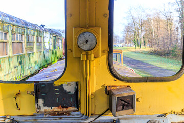 Old passenger carriage seen through window on blurred background, dismantled railway cabin, metal...