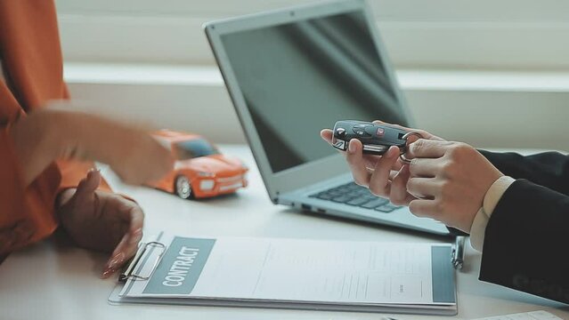 Insurance officers hand over the car keys after the tenant. have signed an auto insurance document or a lease or agreement document Buying or selling a new or used car with a car