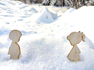 Wooden toys of boy and girl on white snow. Couple in love on Valentine's Day in February. Love in a cold world. Card, background