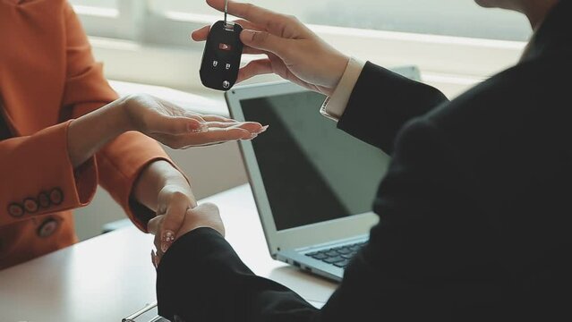 Insurance officers hand over the car keys after the tenant. have signed an auto insurance document or a lease or agreement document Buying or selling a new or used car with a car