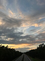 highway in the countryside, dramatic clouds at the sunset sky