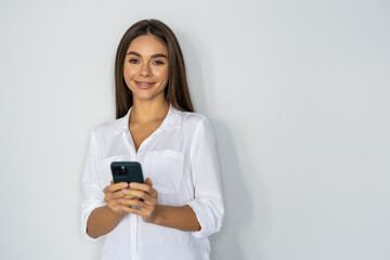Fototapeta premium Portrait of a businesswoman using mobile phone isolated over white background