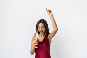 Young celebrating woman red dress isolated over studio background hold wine glass.