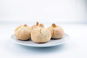 Tipici biscotti sardi morbidi alle mandorle, sul tavolo un piatto, spazio per copiare il testo.