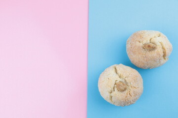 Tipici biscotti sardi alle mandorle, sul tavolo colori rosa e azzurro, spazio per copiare il testo.