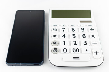 スマートフォンと電卓。通信料のイメージ