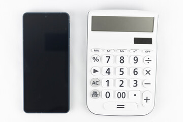 スマートフォンと電卓。通信料のイメージ