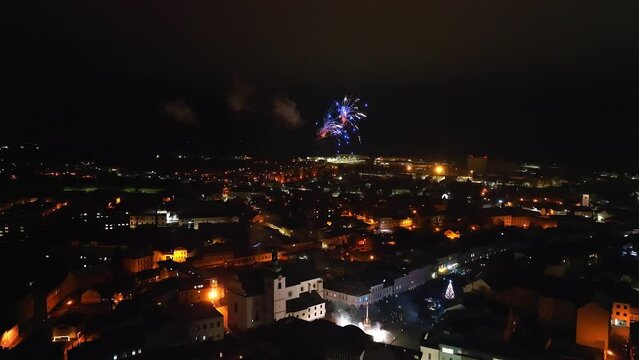 Bursts of colorful lights illuminate city sky as fireworks dazzle the night