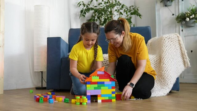 Happy family concept.nanny and child in kindergarten collect toys together. mother helps baby develop.nanny and child in kindergarten spend time together. baby development. happy child in kindergarten