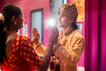 young hindu couple join hands for indian ceremony with backlight