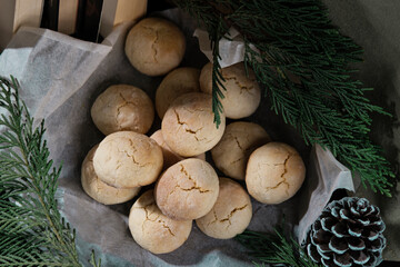 lemon crinkle cookies in bakery paper decorated with corns, books, pine tree branches, cozy winter family holidays with homemade baked bisquits