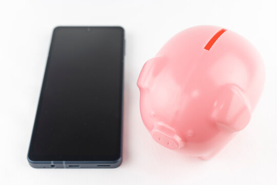 スマートフォンと貯金箱。ネットバンキングのイメージ