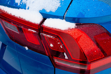 Close-up of red tail lights of a modern car in the winter season.