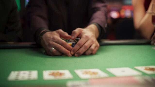 Anonymous Man Dressed in Suit Collecting his Prize of Poker Chips in a Modern Casino. Lucky Male Winner Hitting the Jackpot, Happy About His Risky Bet that Paid of Handsomely. Slow Motion Grab
