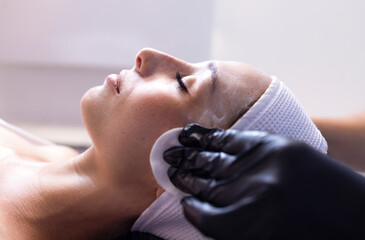 Fototapeta premium Close up of beautiful young brunette woman during facial cleansing and massage