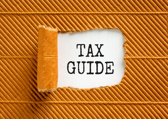 Tax guide symbol. Concept words Tax guide on beautiful white paper. Beautiful brown paper cardboard background. Business and Tax guide concept. Copy space.