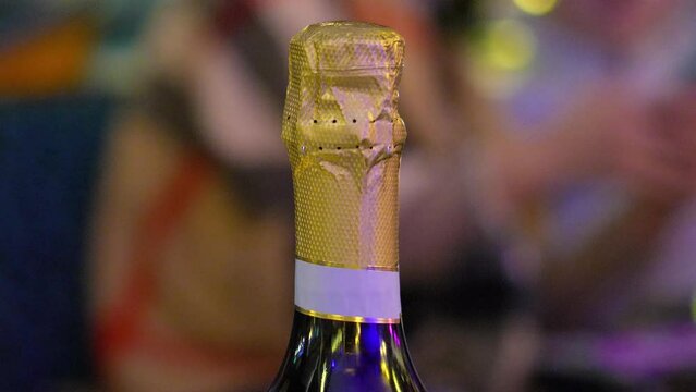 Neck of a green champagne bottle in golden color