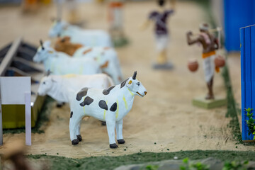 Handmade idol of cow in farming field made with clay. Selective focus.