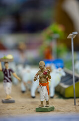 Handmade idol of indian farmer while working in farming field made with clay. Selective focus.