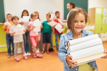 Fototapeta na wymiar Smiling schoolgirl holding books in class