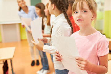 Schoolgirl holding sheet during choir practice