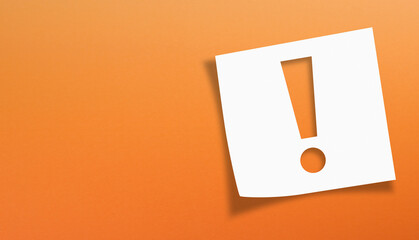 Note paper with exclamation mark on orange background	