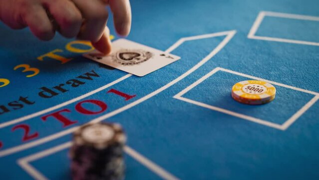 Close Up on Casino Baccarat Gambling Table: Anonymous Croupier Dealing Playing Cards on a Blackjack Table with Bet Chips in Place. Poker Chips are Being Exchanged as the Lucky Guest Wins the Jackpot