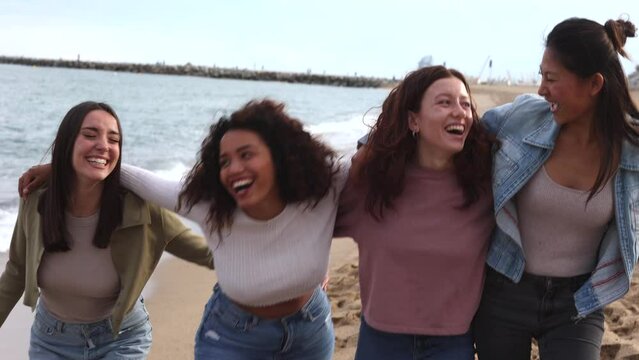 open shot of diverse ethnic friends running free empowered on the beach